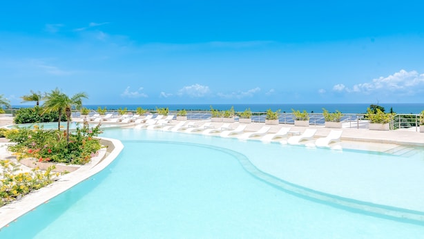 Une piscine avec des chaises longues et vue sur l’océan.