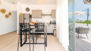 Une cuisine moderne avec un coin repas, une grande fenêtre et une vue sur l’extérieur.