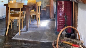 A rustic kitchen with wooden furniture, a stone wall, and a red cabinet. - Cà Nova 1590, a charming accommodation in an ancient hamlet (Emilia-Romagna)