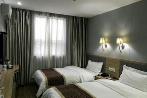 A hotel room with two beds, a desk with a lamp, a window with curtains, and wall-mounted lights. - Huayi Commercial Hotel (Jiyuan)