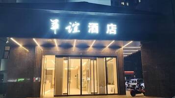 Entrada de hotel con un cartel sobre las puertas.