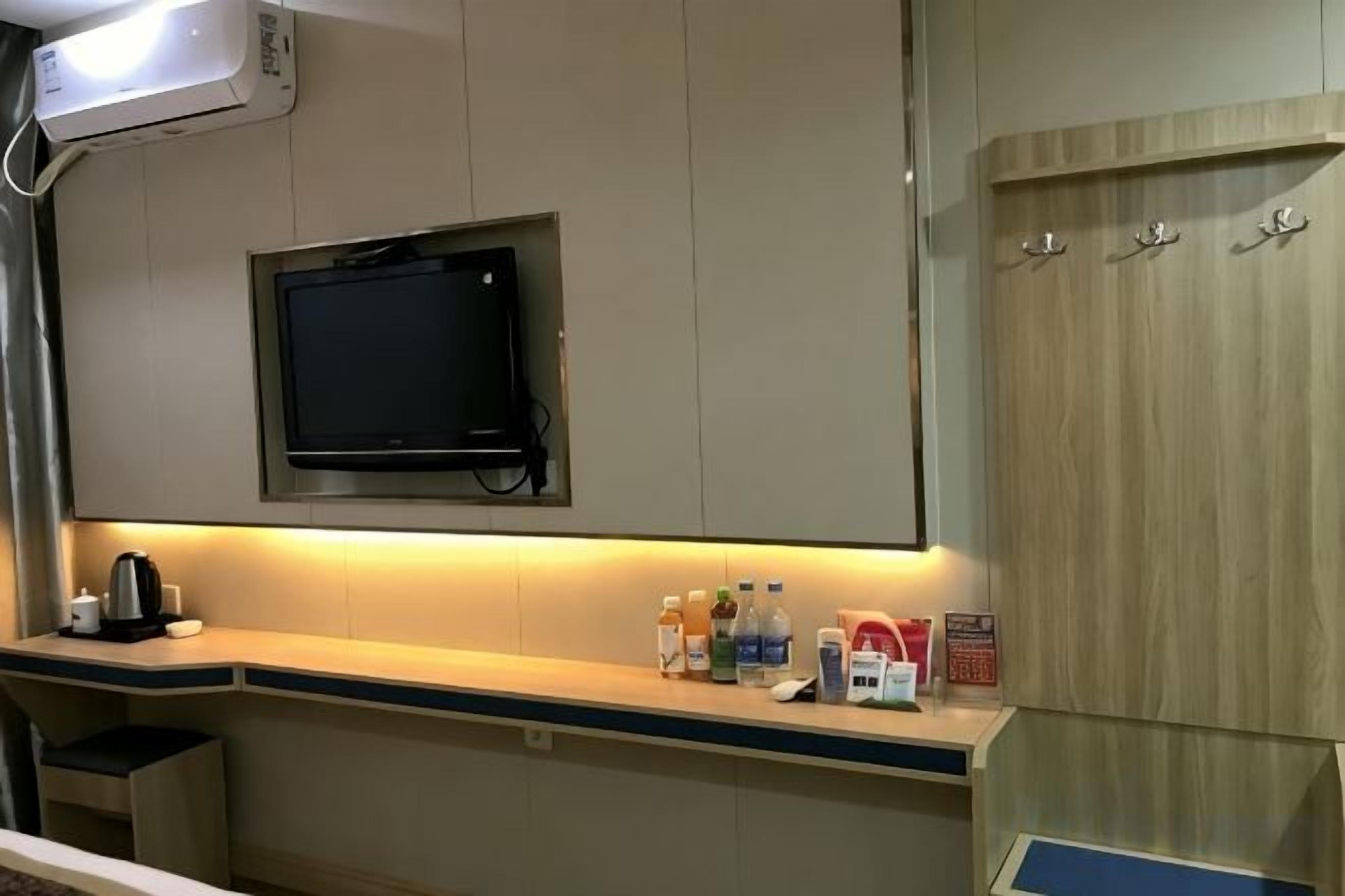 Una kitchenette pequeña con un televisor, una cafetera y un microondas.