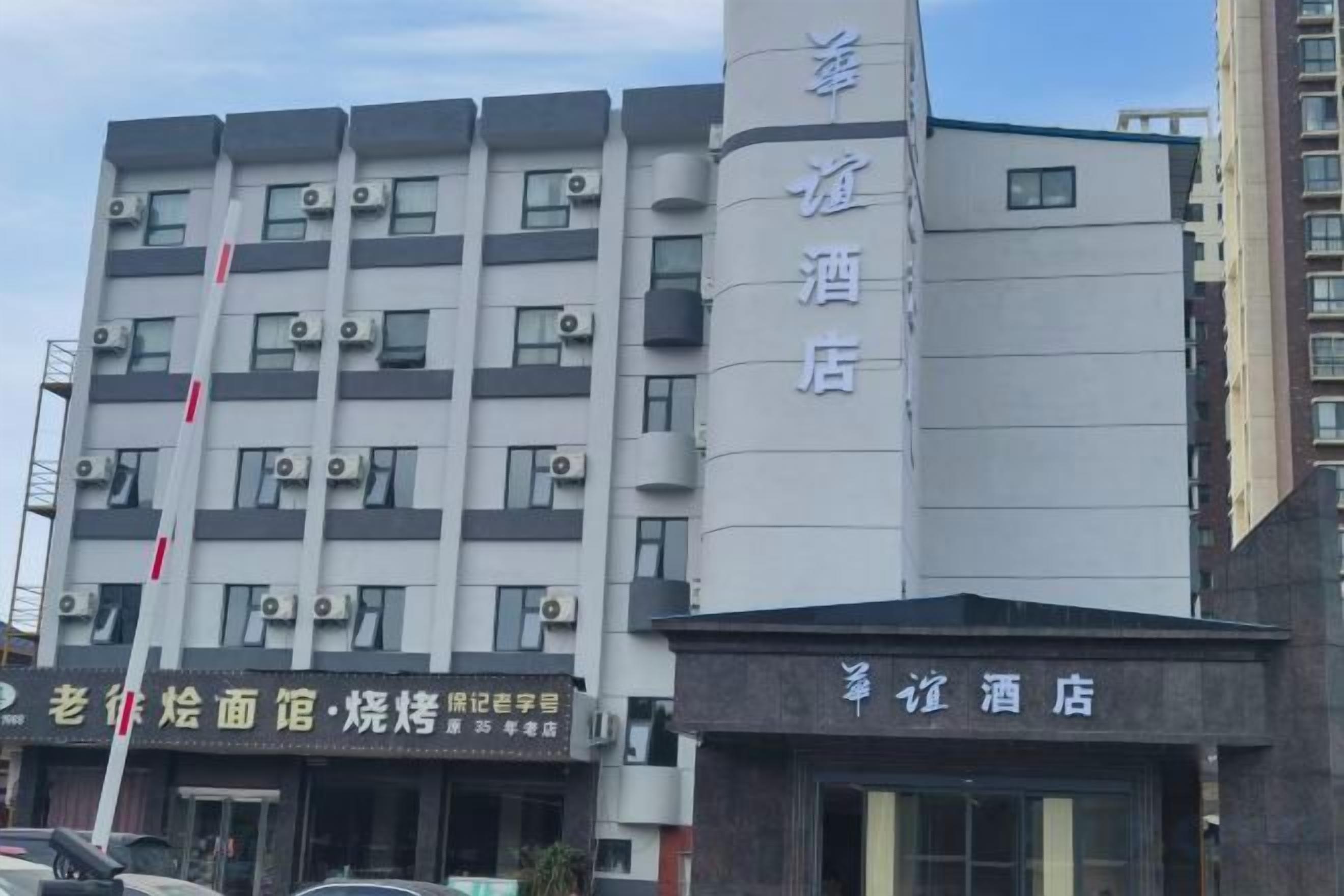 Un hotel de varios pisos, con un letrero vertical llamativo y una fachada con señalización.