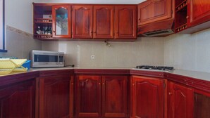 A kitchen with wooden cabinets, a microwave, and a stove.