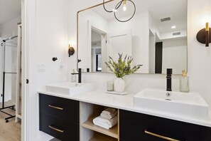 A modern bathroom with two sinks, a large mirror, and a towel rack. - Condo for 4 Overlooking Downtown Collingwood (Collingwood)
