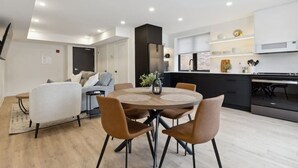 A modern apartment with a dining area, kitchen, and living space.