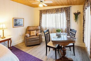 Relax in this inviting space with a comfortable sofa, dining table, and framed artwork.