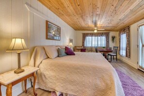 Cozy bedroom with a large bed, bedside tables, and a small dining area.