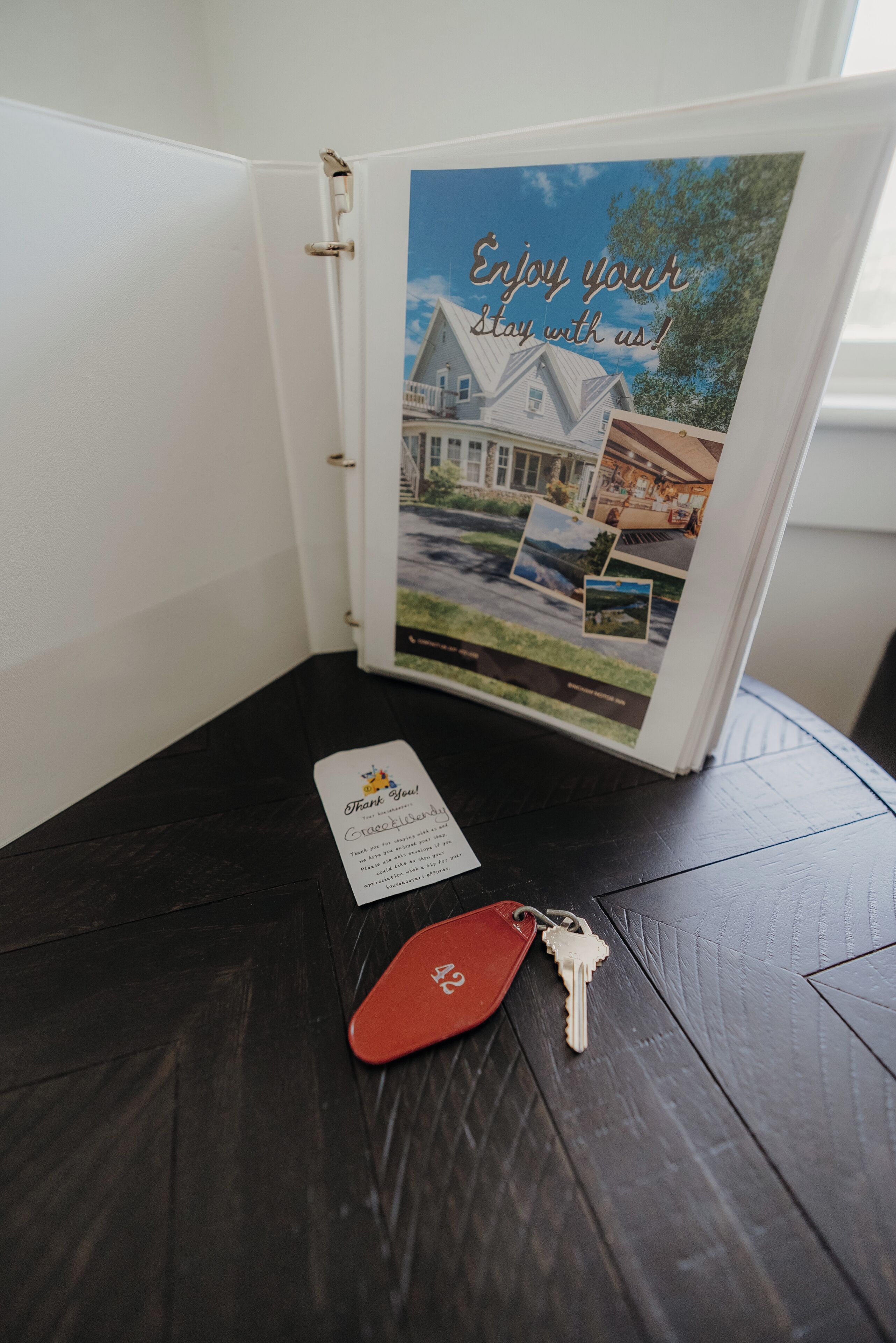 A binder with a photograph of a house and the text "Enjoy your stay with us!" on the cover.