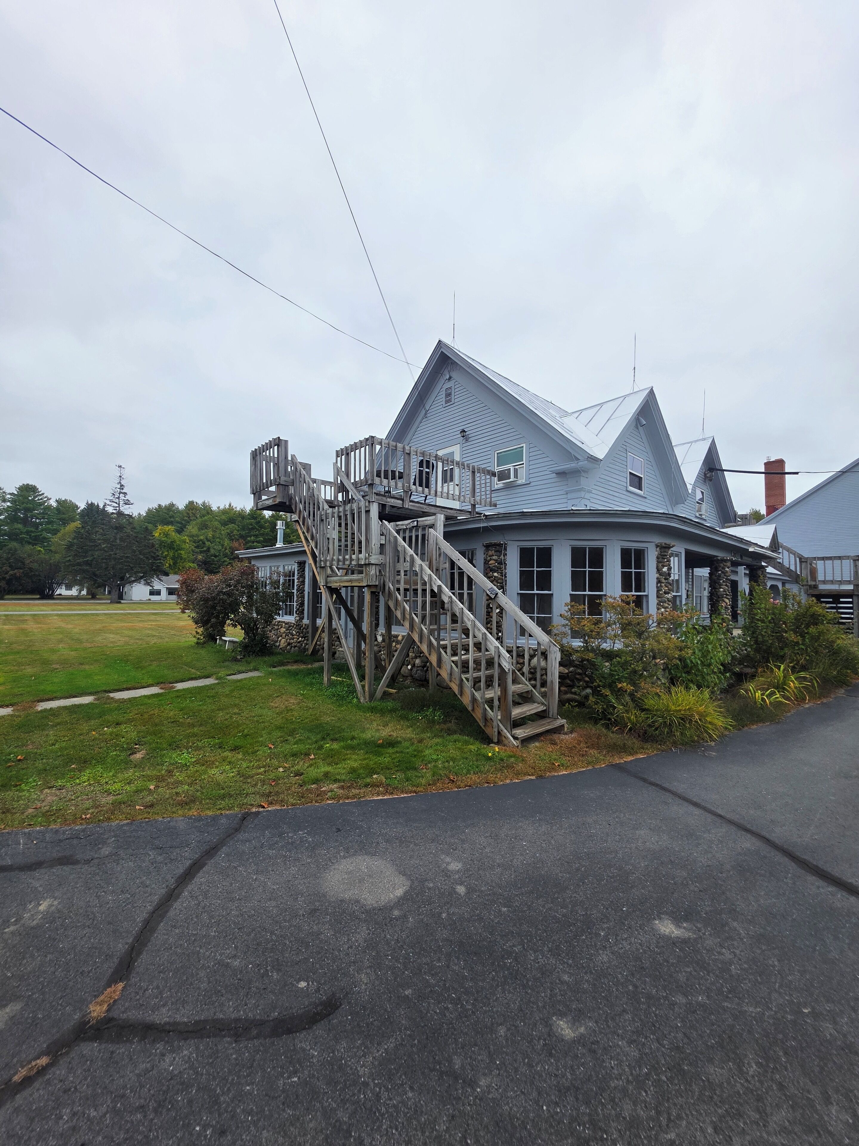 A two-story house with a wooden staircase leading to a balcony.