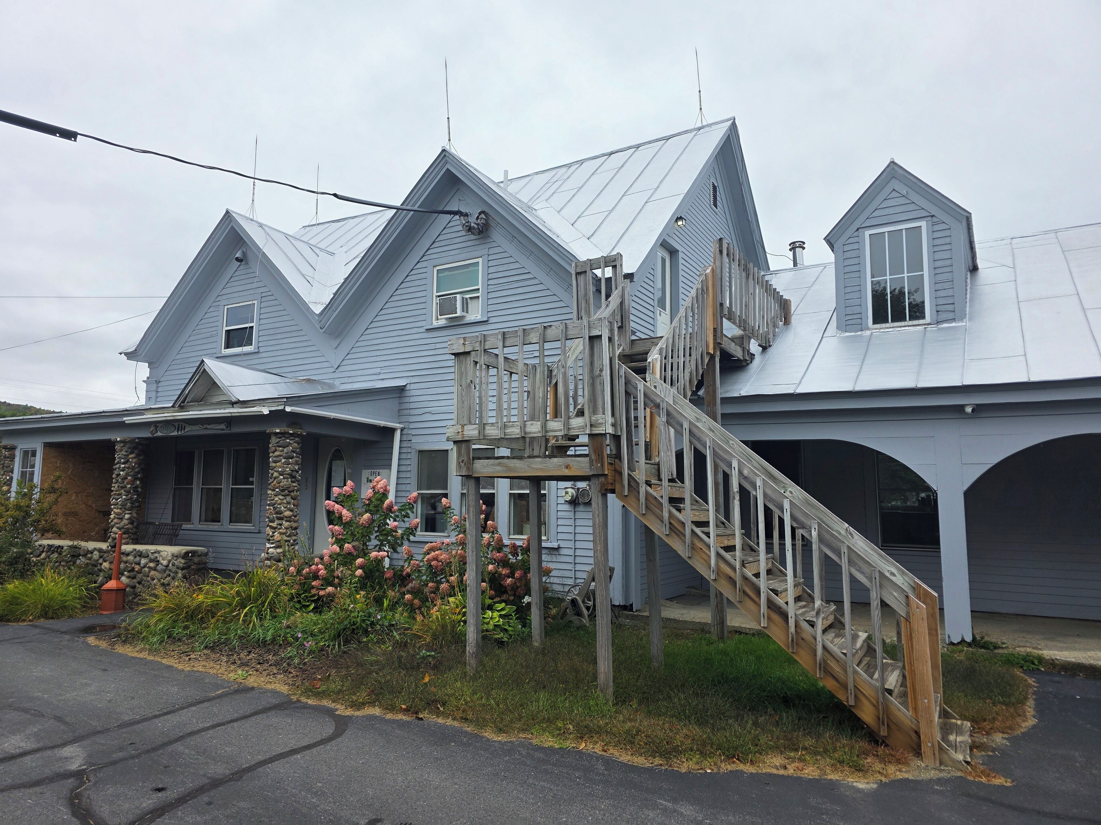 A two-story house with a wooden staircase leading to a porch.