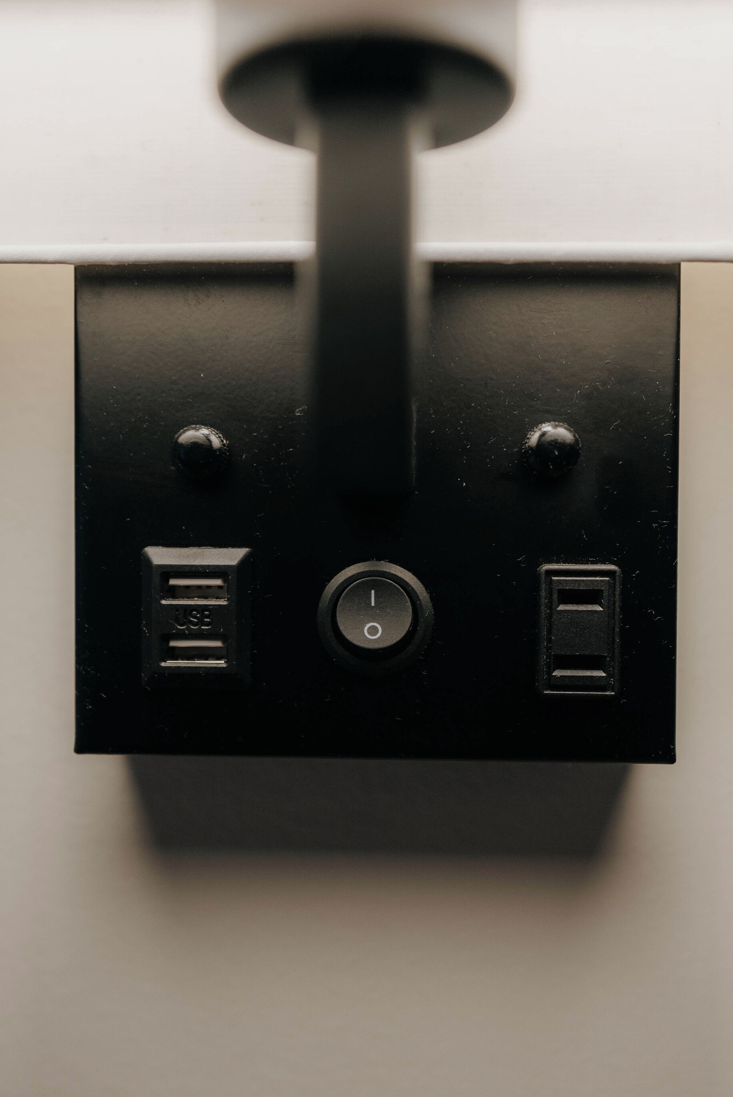 A black electrical panel with three switches and a USB port.