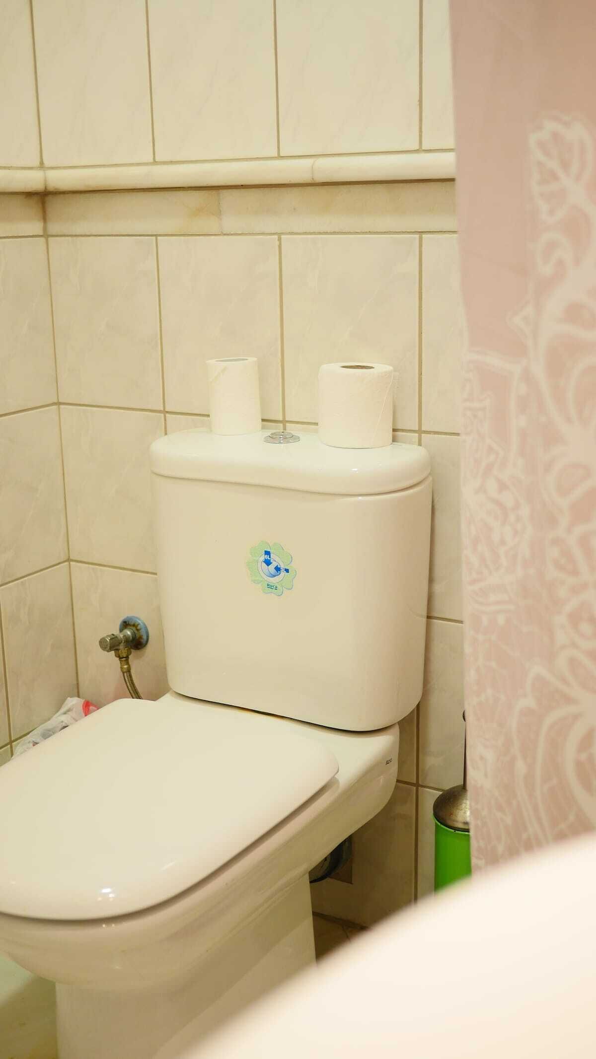 Un inodoro con un adhesivo que indica ahorro de agua.