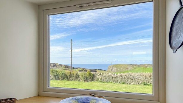 A window with a clear view of a grassy landscape and a stone wall. - 1 bedroom accommodation in Drummore, near Stranraer (Drummore, near Stranraer)