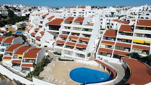 Un hôtel de grande hauteur doté de nombreux balcons, d’une piscine centrale et offrant une vue sur les bâtiments environnants.