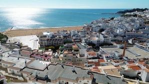 Une ville côtière aux bâtiments blancs, avec une plage et une vue sur la mer.