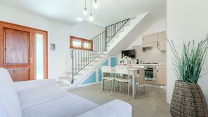 Una sala moderna con una escalera que conduce a una cocina.