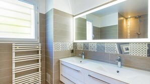 A bathroom with two sinks, a large mirror, and a towel rack.