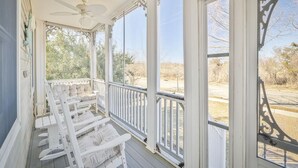 A covered porch with white railings and multiple rocking chairs. - Ocean View Cape May Beach Home w/ Deck | Sleeps 14 (Cape May)