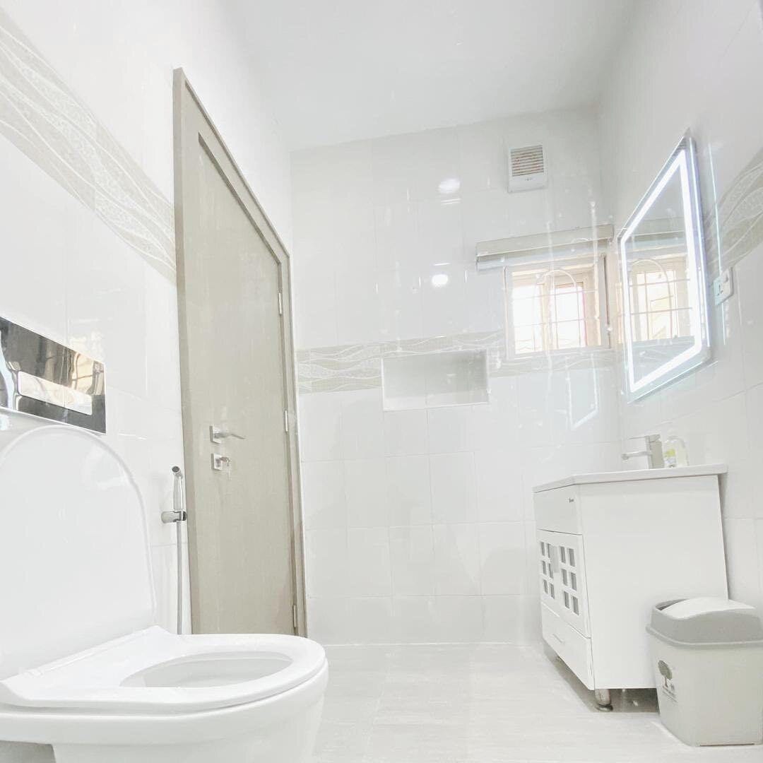 A bathroom with a toilet, a sink, and a mirror.