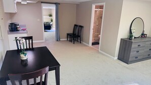 A spacious living room with a dark wooden dining table and chairs, a grey sofa, and a grey cabinet with a mirror. - Private, huge walk-out basement, great location (Marietta)