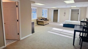A spacious room with a large bed, a sofa, and a dining table. - Private, huge walk-out basement, great location (Marietta)