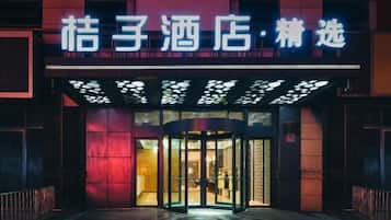 A hotel entrance with a revolving door and illuminated signage.