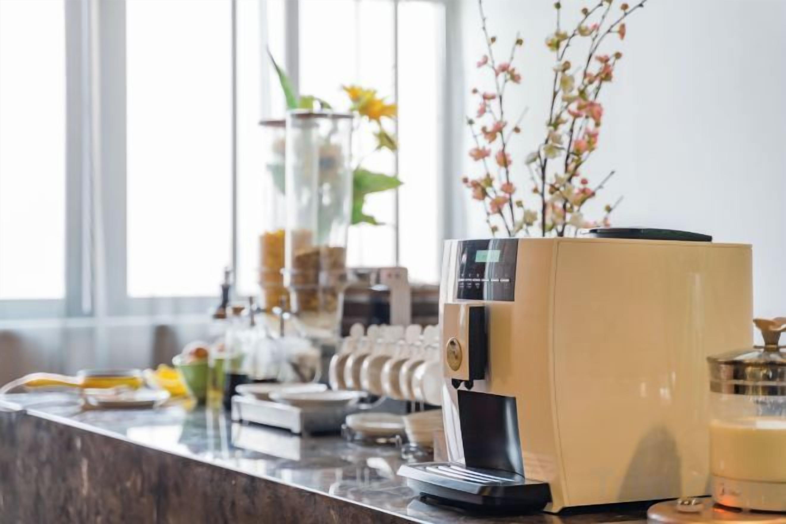 A coffee machine and a glass container on a counter.