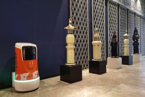 Una serie di oggetti esposti su una parete decorata, con un moderno oggetto simile a un veicolo a sinistra.
