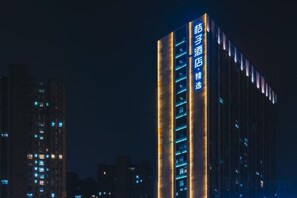Un edificio de gran altura con señalización iluminada, varios pisos y un diseño arquitectónico moderno.