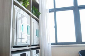 A room with a window, a white cabinet with drawers, and a plant on top. - Orange Hotel (Wuxi Oufeng Street Huishan Ancient Town Branch) (Wuxi)