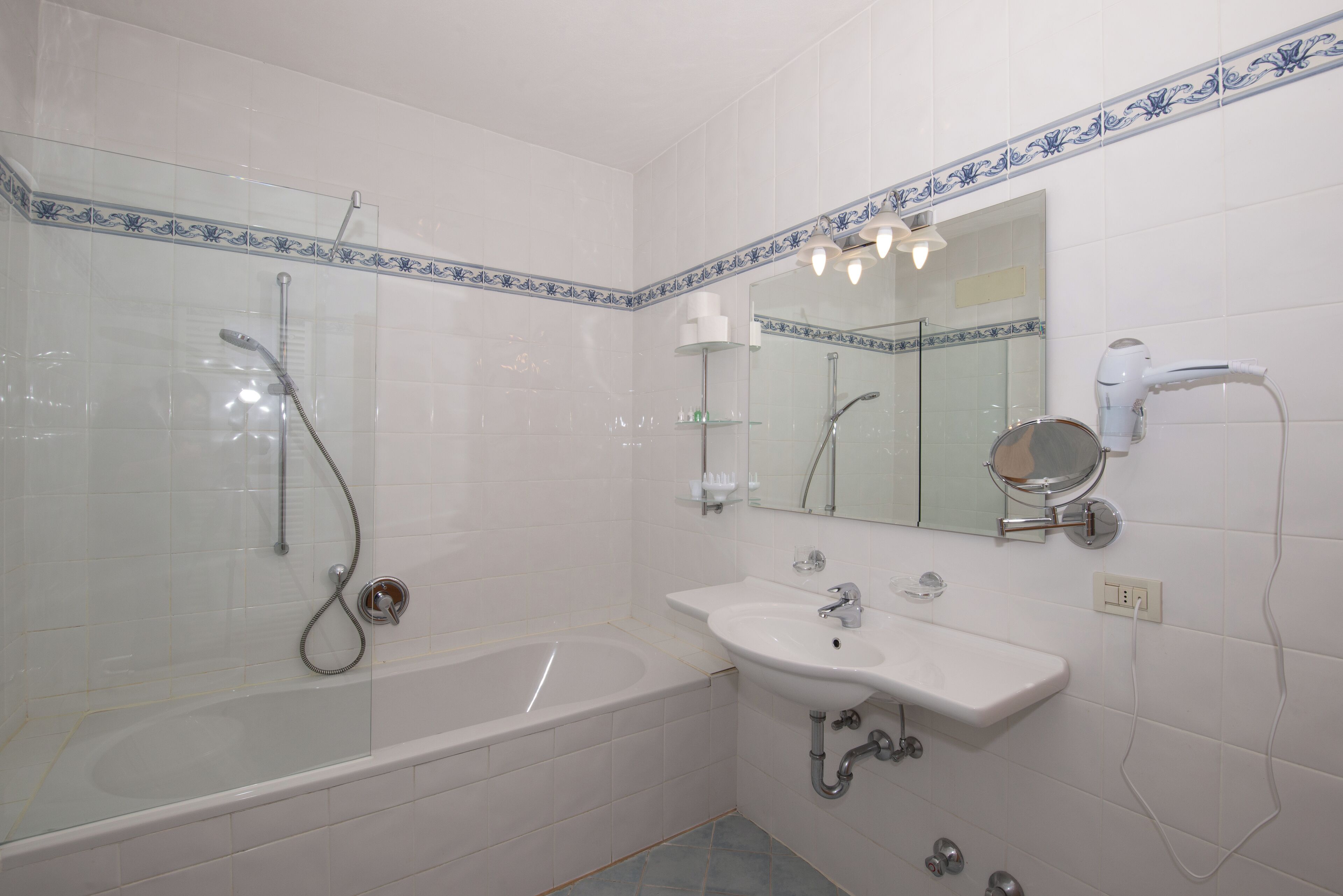 Une salle de bain dotée d’une douche à parois de verre, d’une baignoire et d’un lavabo avec un miroir au-dessus.
