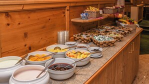 A buffet with various food items and condiments. - Erlebnishotel Engel (Sluderno)