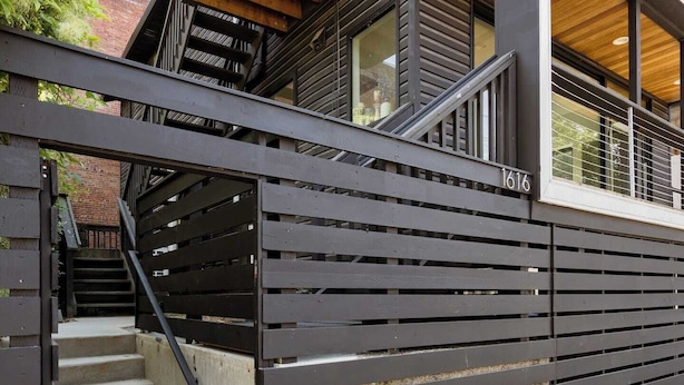 Un bâtiment moderne avec un escalier menant à une terrasse en bois.