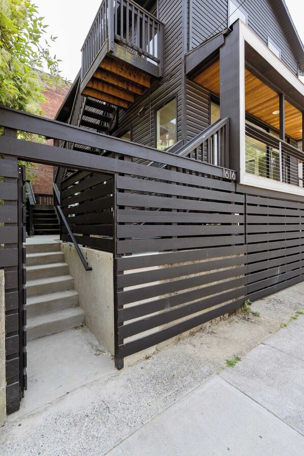 A modern building with a staircase leading to a wooden deck.