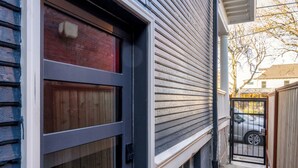 A residential building with a garage door, a concrete pathway, and a gated driveway. - Renovated 2BR Garden Suite • Steps to NW 23rd (Portland)