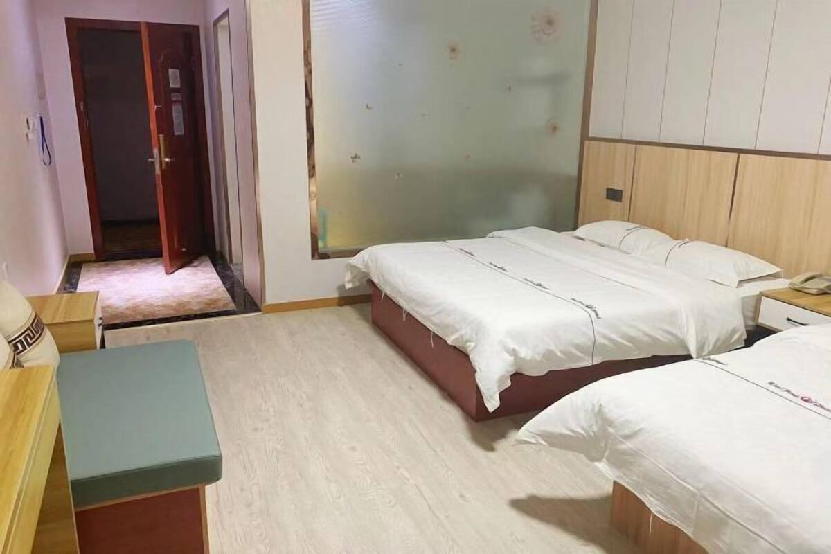 Una habitación de hotel con dos camas, un escritorio y un armario.