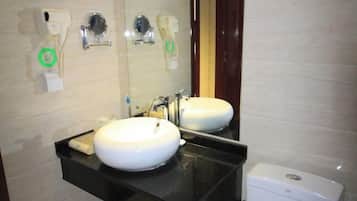 Un baño con dos lavamanos, un espejo y un inodoro.