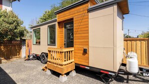 A mobile home with a wooden deck, a sliding door, and a propane tank. - Classic 1920s Alberta Home + 2 Tiny Homes (Portland)