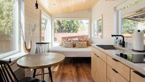 A compact kitchen with a dining area, wooden ceiling, and large windows. - Classic 1920s Alberta Home + 2 Tiny Homes (Portland)