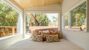 A bedroom with a large bed, a view of the outdoors, and an exit sign. - Classic 1920s Alberta Home + 2 Tiny Homes (Portland)