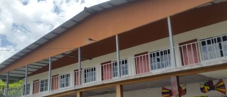 A multi-story building with a flat roof and a covered walkway.