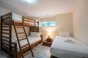 A room with bunk beds, a bedside table with a lamp, and a window. - The Prima at Blue View Chalets (The Blue Mountains)