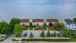 Un quartier résidentiel comprenant trois maisons, un parking et, au loin, un plan d’eau.