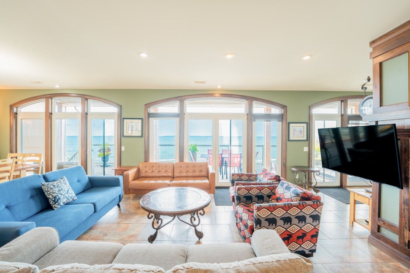 A spacious living room with a blue sofa, a patterned sofa, and a coffee table.