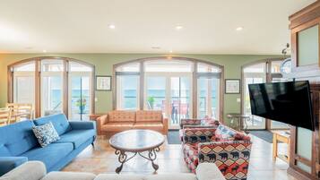 A spacious living room with a blue sofa, a patterned sofa, and a coffee table.