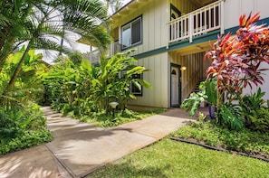 Stroll through lush tropical gardens to the entrance of this classic hotel, featuring a traditional door and inviting atmosphere.