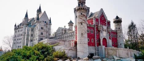 A large, castle-like building with multiple towers and a prominent red section.