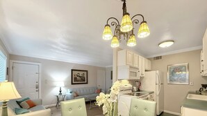 Una sala moderna con una mesa de comedor de vidrio, un sofá y una araña.