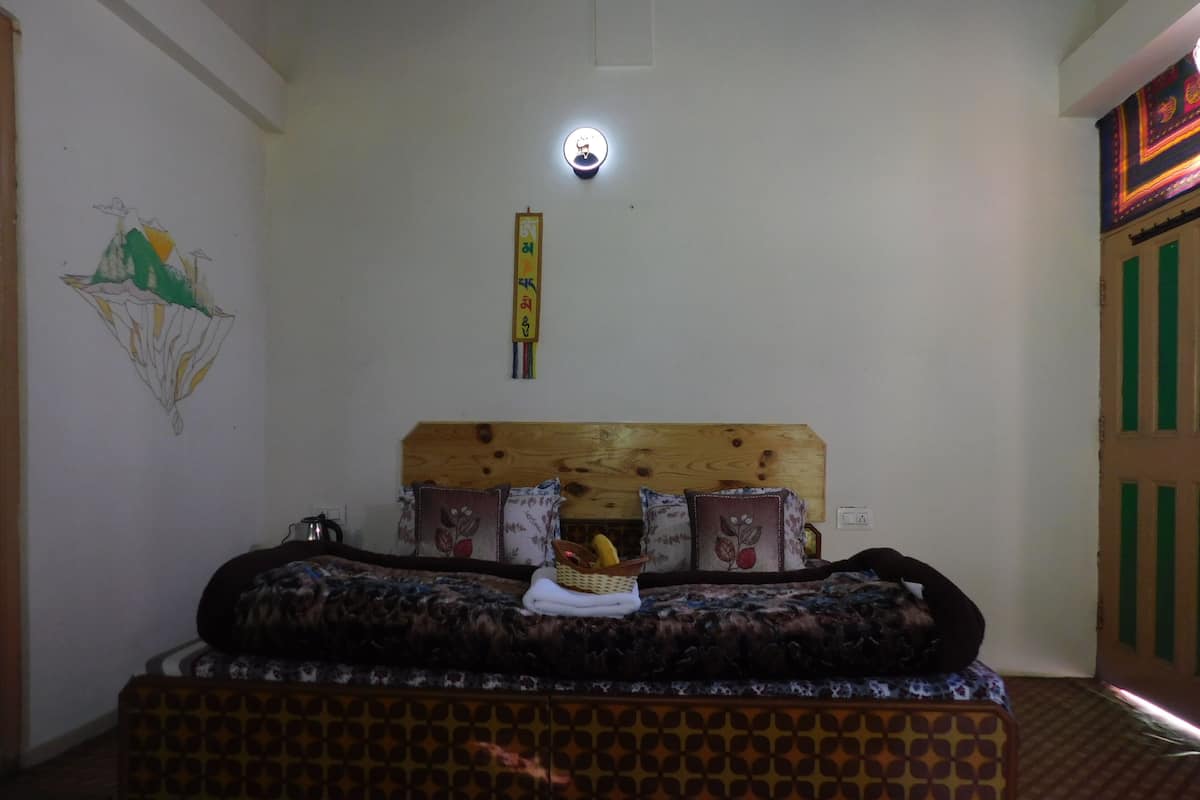 Une pièce comprenant un lit, une lampe fixée au mur et un élément décoratif mural.